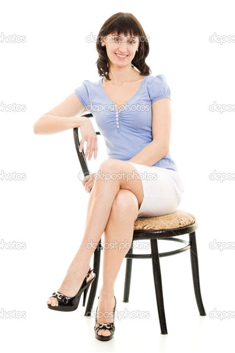 A Woman In Blue Shirt And White Skirt Sitting On Bed With Her Arms