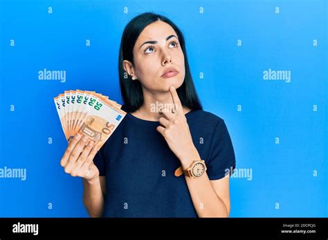 Beautiful Young Woman Holding Bunch Of 50 Euro Banknotes Thinking Beautiful Young Woman Holding Bunch Of 50 Euro Banknotes Thinking